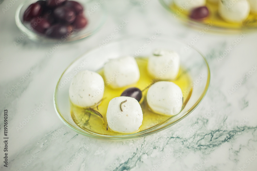 Close-up of Labneh cheese balls from goat milk with herbs, marinated in olive oil, with olives on the side Close-up of Labneh cheese balls from goat milk with herbs, marinated in olive oil, with olives on the side
