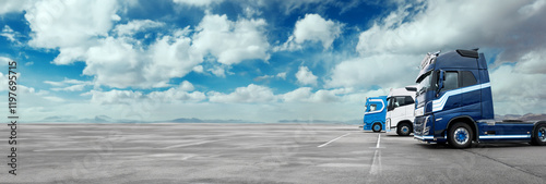 A blue semi truck is parked in front of a large empty road