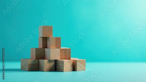 Unassembled wooden blocks arranged in a staggered pyramid formation against a teal backdrop photo