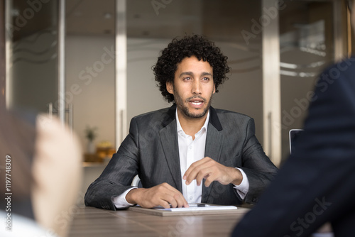 Handsome millennial Arabian male company executive manager hold meeting with shareholders in modern conference room, make speech, provide information, lead formal negotiations with corporate partners