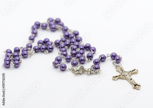 A purple beaded rosary isolated on a white background.