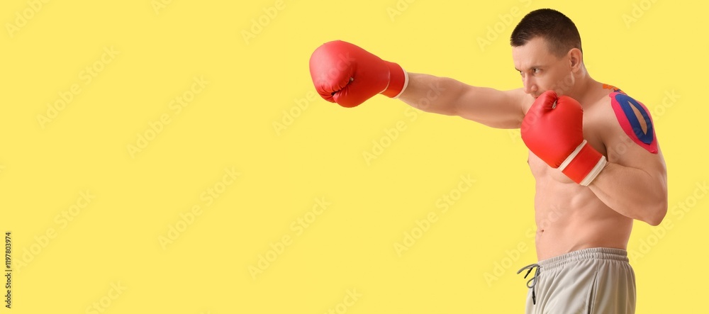 Young male boxer on yellow background with space for text Young male boxer on yellow background with space for text