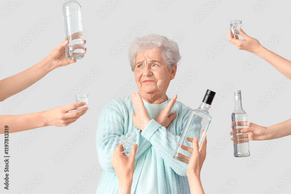 Senior woman rejecting vodka on light background Senior woman rejecting vodka on light background