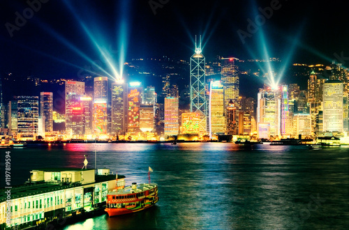 Hong Kong Island China city skyline with night laser light show seen across Victoria Harbour from Kowloon Star Ferry terminal