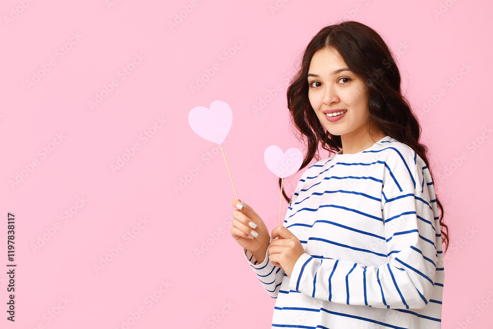 Beautiful young Asian woman with paper hearts on pink background. Valentine's Day celebration Beautiful young Asian woman with paper hearts on pink background. Valentine's Day celebration