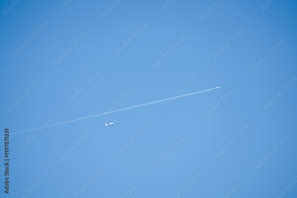 Airbus A380 and a twin engined jet liner aircraft in deep blue sky, contrails vapour trails Airbus A380 and a twin engined jet liner aircraft in deep blue sky, contrails vapour trails