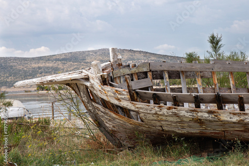 The frame of an old ship with old planks on the seashore