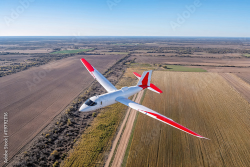 Small airplane flying over agricultural fields on sunny day photo