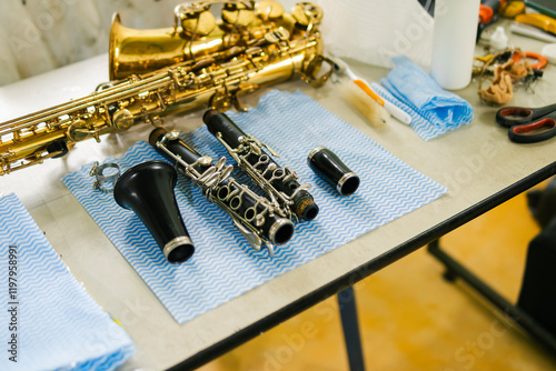 Saxophone and clarinet being repaired on workbench by instrument technician