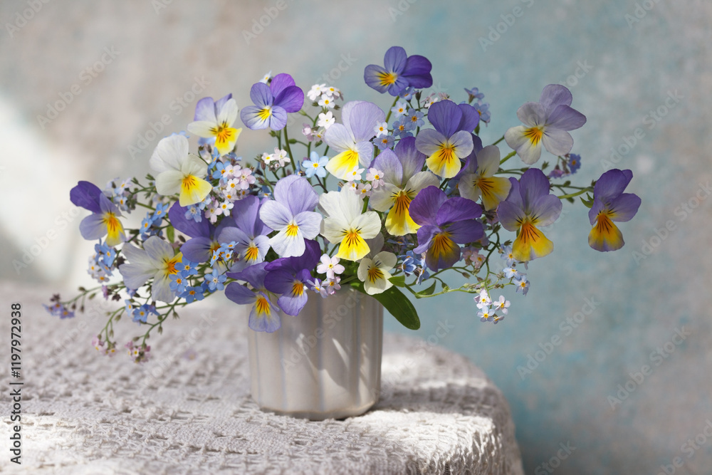 Φωτογραφία Bouquet of pansies and forget-me-not flowers in a vase on the table