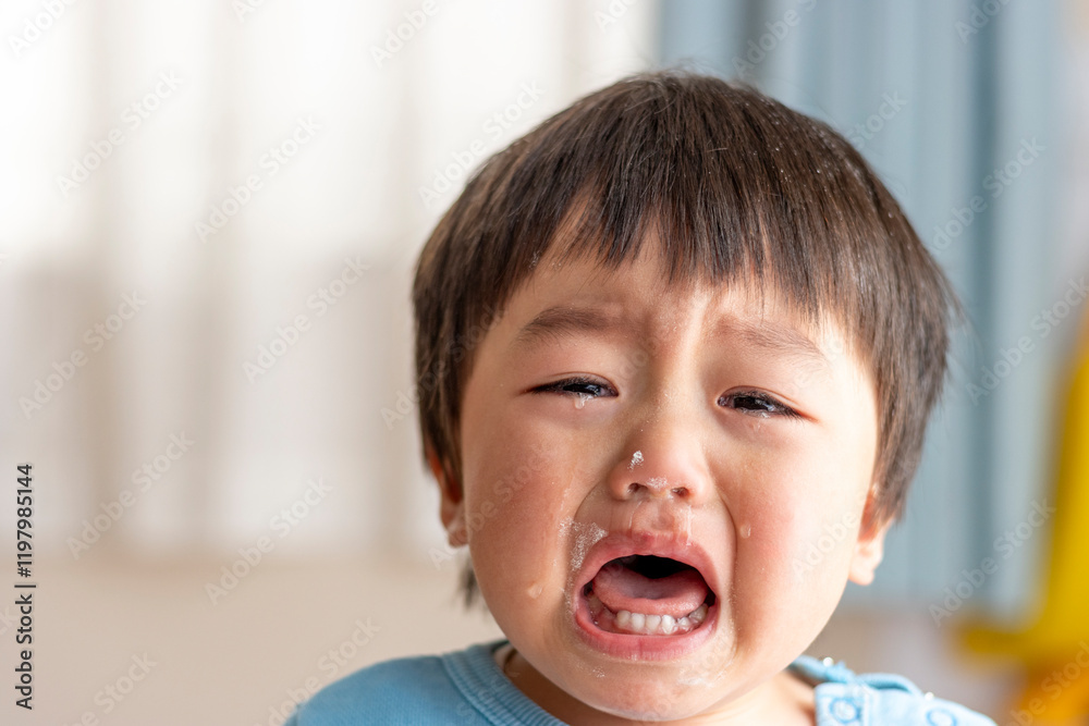 お菓子作り中に泣く子供の顔(男の子、2歳、日本人)