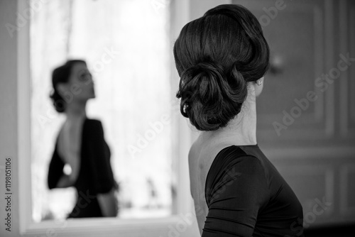 Miss elegance concept. Back of beautiful gracious woman looking at the mirror in a luxury hotel