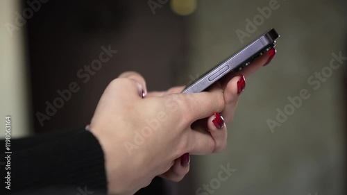 Young woman with red nails chatting on smartphone. Close-up