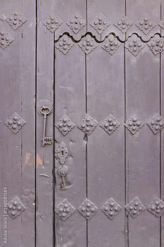 An antique key hanging from an old door. An antique key hanging from an old door.