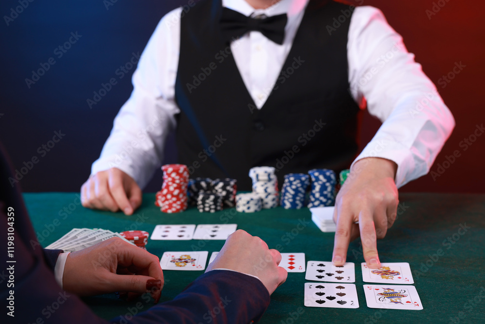Professional croupier and gambler at table with playing cards and casino chips, closeup Professional croupier and gambler at table with playing cards and casino chips, closeup