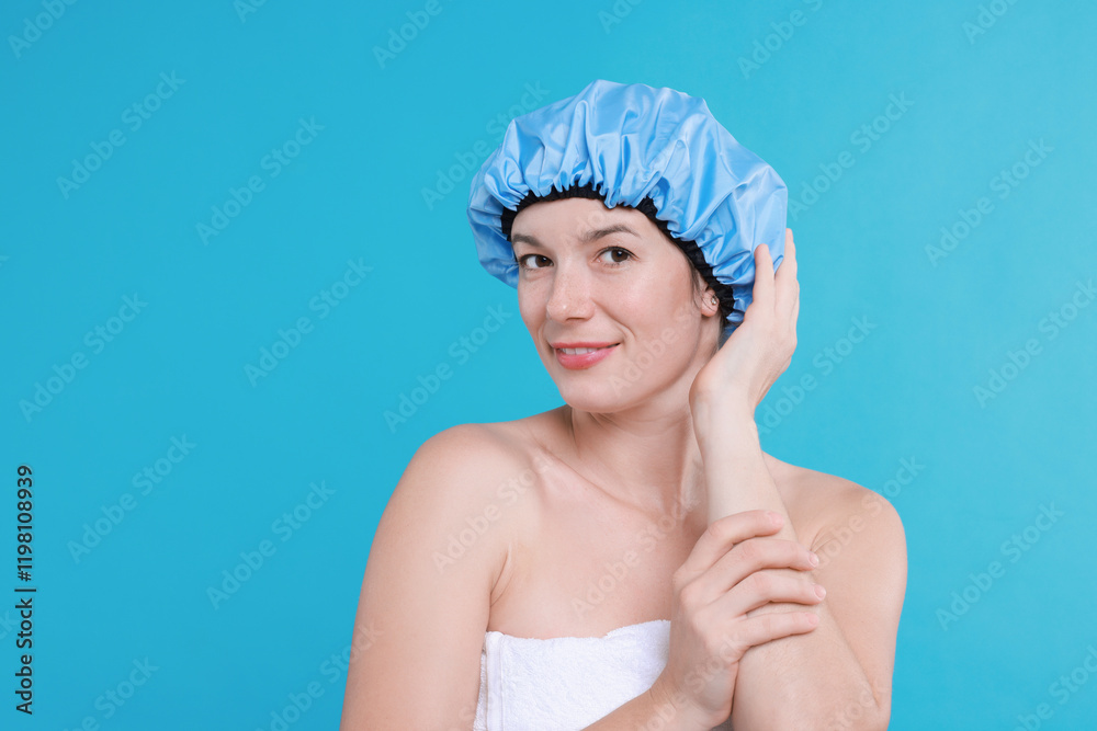 Woman wearing shower cap on light blue background Woman wearing shower cap on light blue background