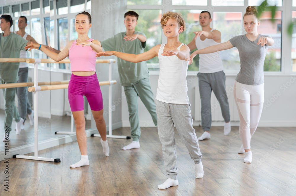 Fototapeta premium Girls and boys are learning various dance and ballet movements in the studio