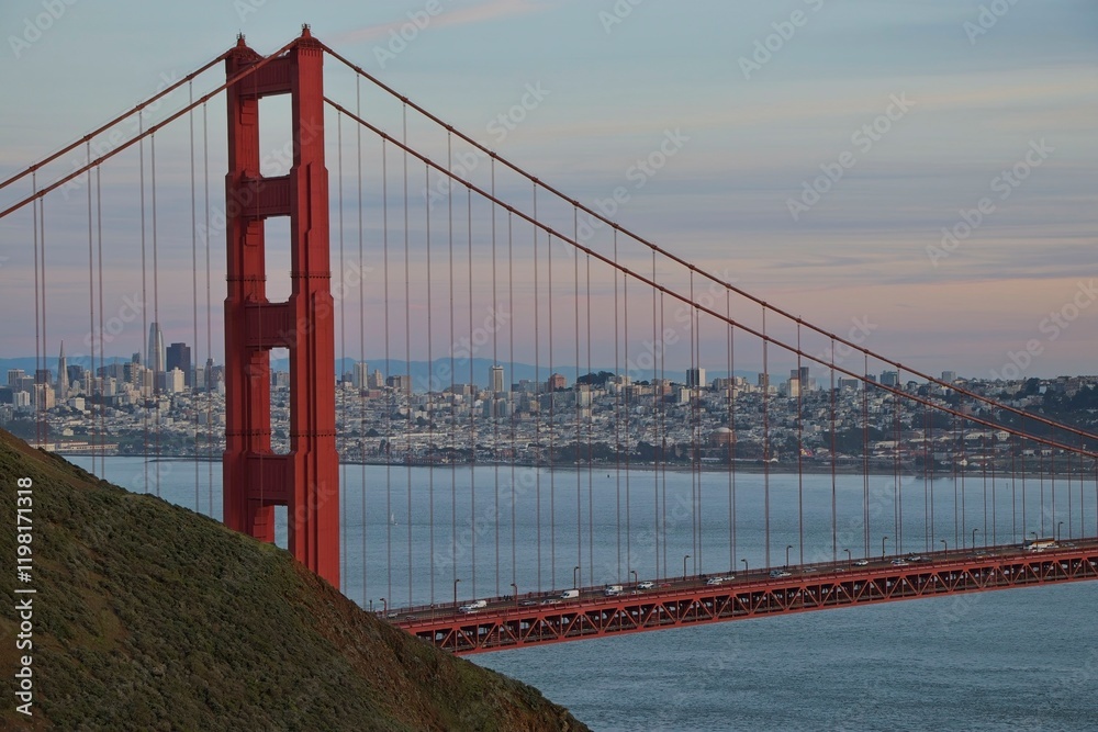 Obraz premium The sun sets on the Golden Gate Bridge at the mouth of the San Francisco Bay