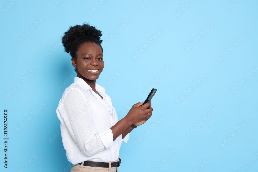 Happy woman with smartphone on light blue background. Space for text Happy woman with smartphone on light blue background. Space for text