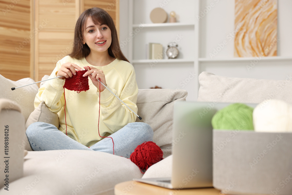 Beautiful woman learning to knit with online course at home Beautiful woman learning to knit with online course at home