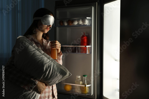 Young woman suffering from sleepwalking near fridge at home