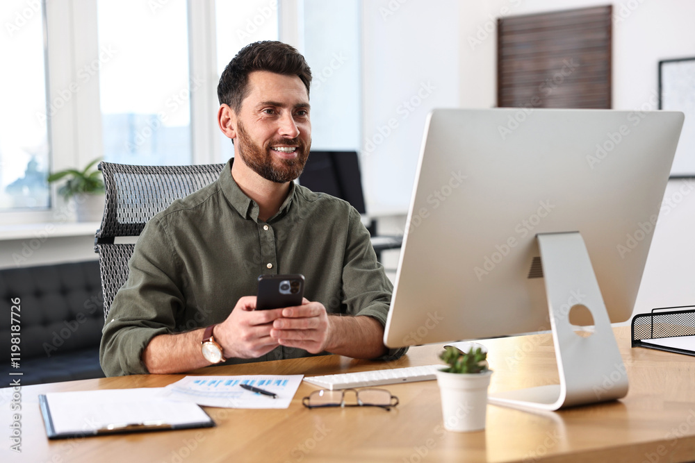 Fototapeta premium Man using smartphone at table in office