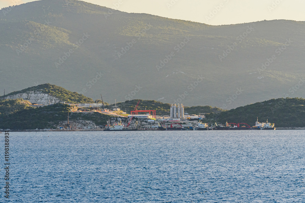 Fototapeta premium Early Construction Phase of Peljesac Bridge in Southern Croatia at Sunset with Scenic Mountain Backdrop