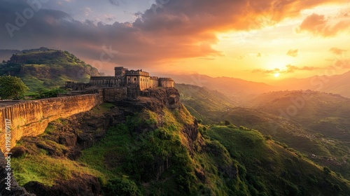 A panoramic view of the majestic Bhujia Fort against a vibrant sunset, highlighting the rugged terrain and historic architecture,