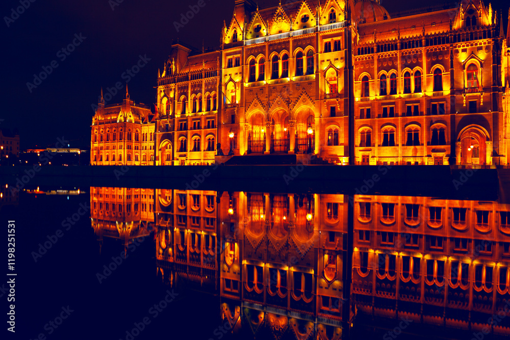 Illuminated architectural marvel reflecting in calm waters at night. Hungarian Parliament Building showcasing symmetry, rich warm tones, and elegant historic details for use in creative projects