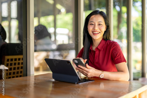 A woman is sitting at a table with a laptop and a cell phone Free Download A woman is sitting at a table with a laptop and a cell phone - GFXLoad