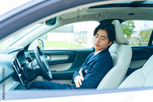 居眠り、運転、ビジネスマン、ドライブ、男性、自動車、ドライバー、眠る、休憩、自動運転、車中泊、リラックス、寝不足、駐車場、パーキングエリア、サービスエリア、運転席、シート、昼寝、仮眠、交通、クルマ、オートモーティブ、モビリティ、自動、パーキング、スーツ、営業、疲労、長距離、高速道路、疲れ、シートベルト、運転手、車内、インテリア、日本人、仕事、通勤、商用車、社用車、宿泊、渋滞、災害、被災地、停車、駐 photo