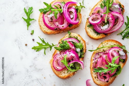 Small bite sized sandwiches featuring sweet pickled red onion salt herring and greens on a light marble surface viewed from above photo