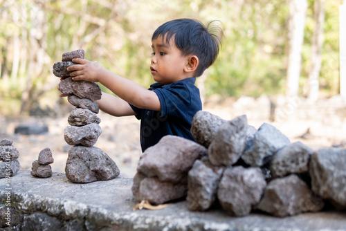 Close up little boy stacking stones balance