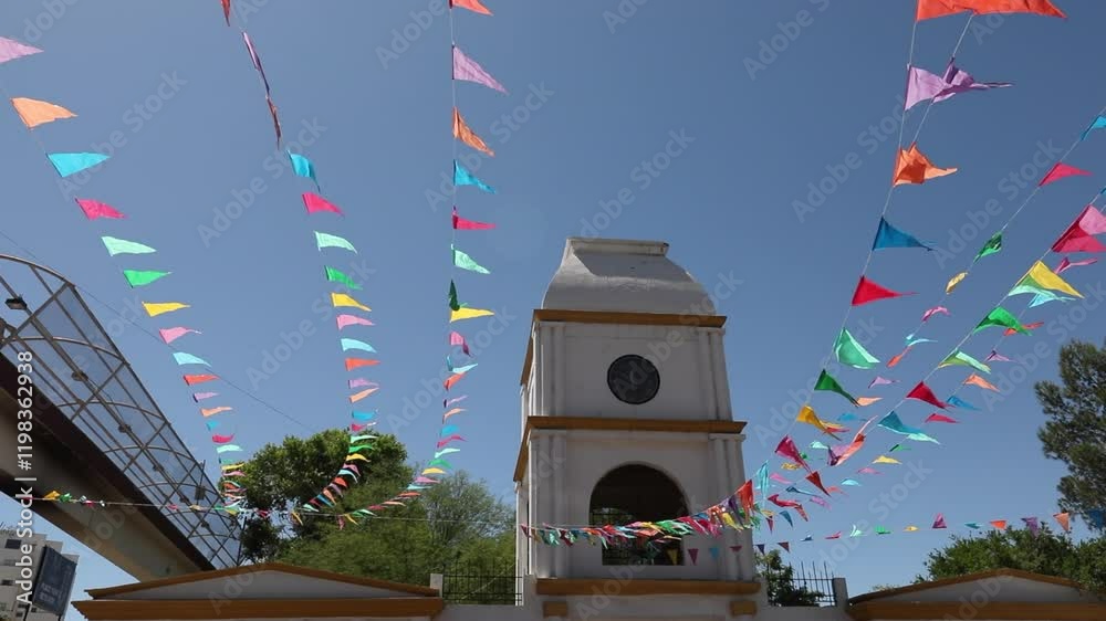 Colorful papel picado frames the historic clock tower of the downtown train station in Heroica Nogales, Sonora, Mexico.