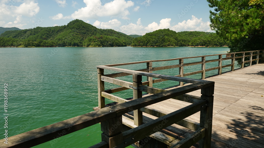 A wooden pavilion extends over the lake, with sunlight casting bright reflections on the surface, hangzhou China. High quality photo A wooden pavilion extends over the lake, with sunlight casting bright reflections on the surface, hangzhou China. High quality photo