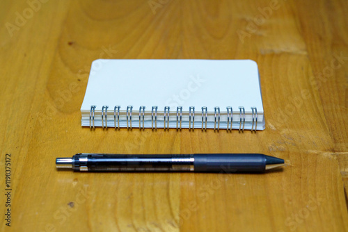 opened notebook paper with black pen on white desk, copy space