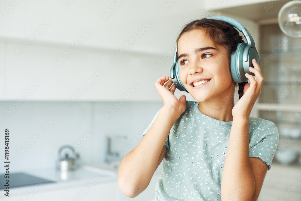 Naklejka premium Cute girl with pigtails with headphones listening to music at home