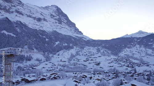 dolly sideways right to left over grindelwald village centre at dusk, stunning view of Eiger North Face photo