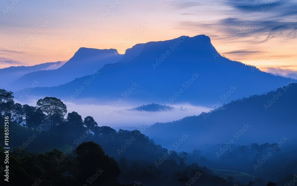 Obraz premium Misty Mountain Range at Dusk with Silhouette Peaks and Pastel Sky.