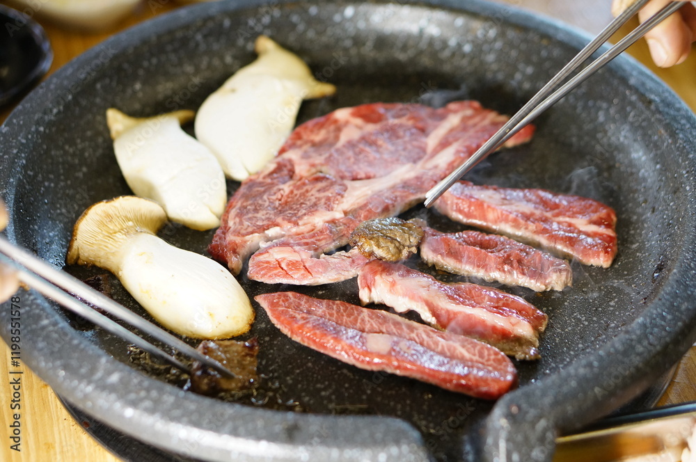 불판 위에서 소고기를 맛있게 굽고 있는 모습 불판 위에서 소고기를 맛있게 굽고 있는 모습