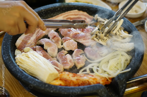 불판 위에서 삼겹살을 맛있게 굽고 있는 모습 photo