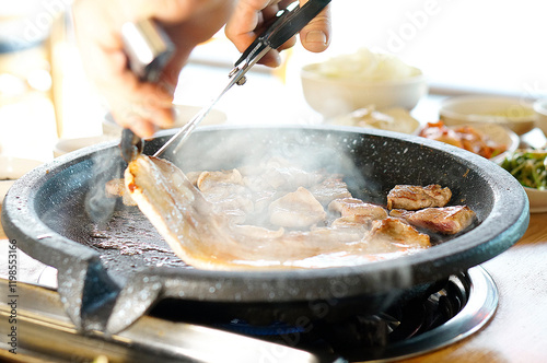 불판 위에서 삼겹살을 맛있게 굽고 있는 모습 photo