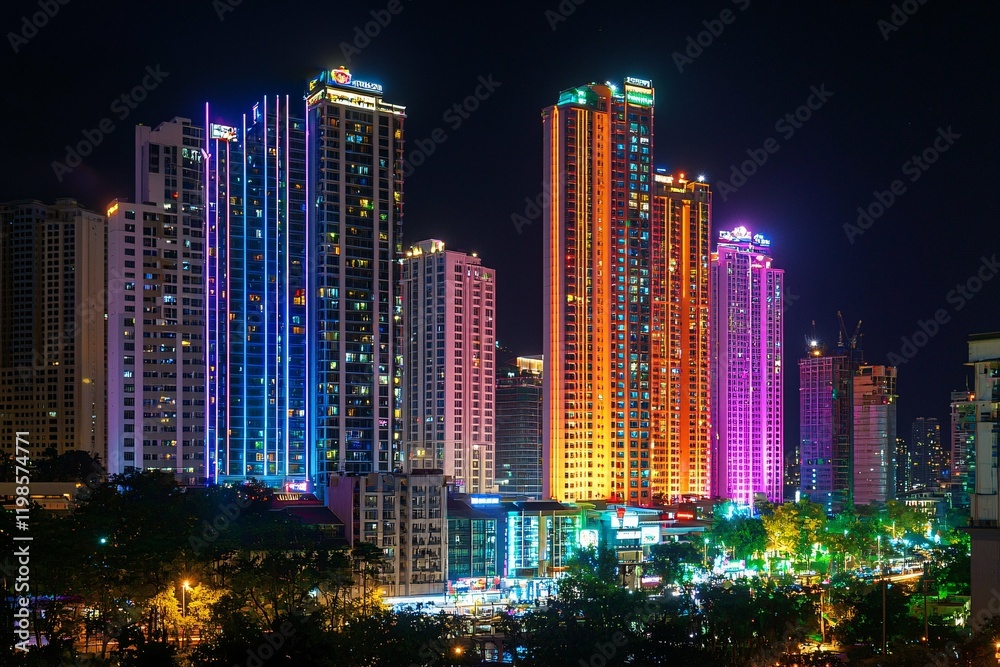 Fototapeta premium Bright city lights at night bring to life a bustling metropolis, with colorful skyscrapers radiating energy and excitement throughout the urban landscape.
