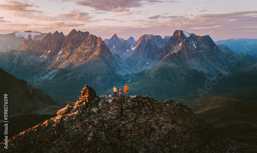 Aerial view in Norway - family travel climbing mountains mother, father, and child on summit together adventure trip parents and kid on active vacations tour outdoor in Lyngen Alps sunset landscape