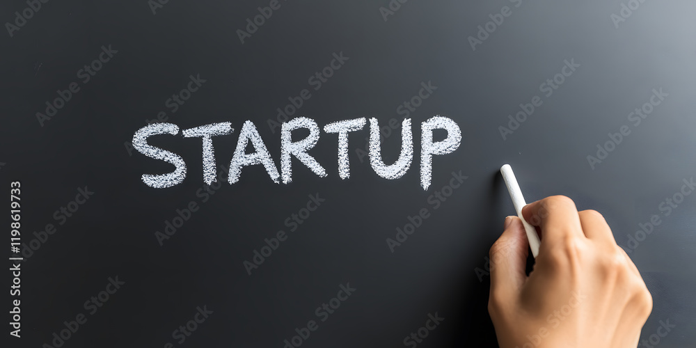 The word 'STARTUP' written in chalk on a blackboard. A hand is holding a piece of chalk, adding to the word. The word 'STARTUP' written in chalk on a blackboard. A hand is holding a piece of chalk, adding to the word.