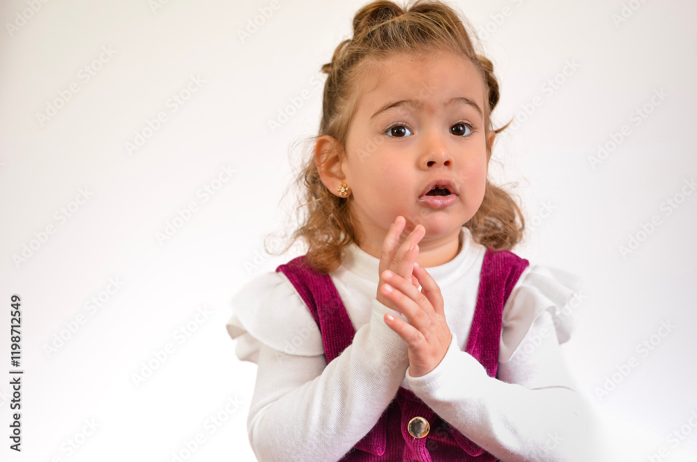 Cute toddler girl clapping hands and looking surprised on white background Cute toddler girl clapping hands and looking surprised on white background