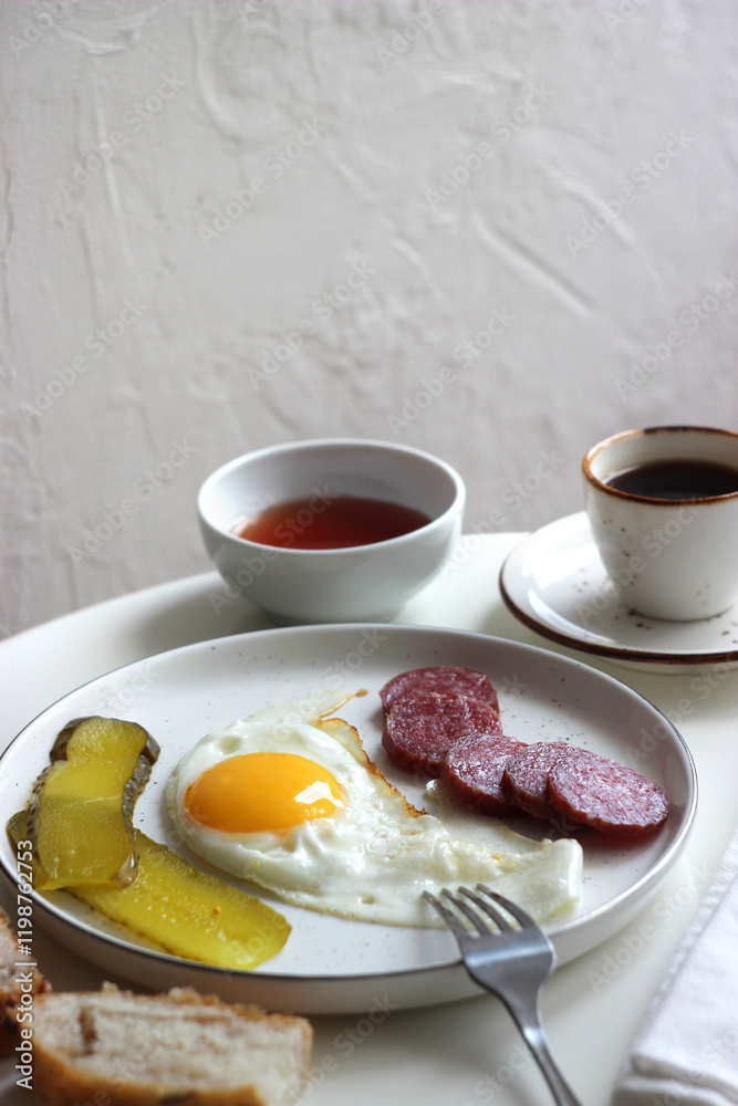 Scrambled eggs, smoked sausage and pickles in a plate on the table. Scrambled eggs, smoked sausage and pickles in a plate on the table.