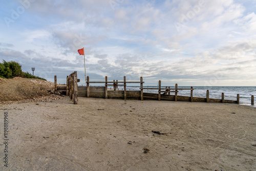 Dark clouds and a red flag on the beach in West Wittering, West Sussex, England, UK photo