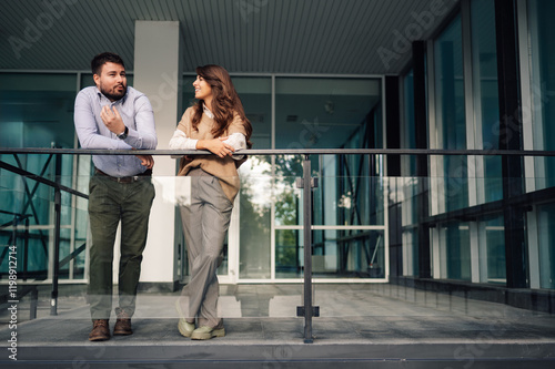 Business people having informal conversation on office building balcony photo