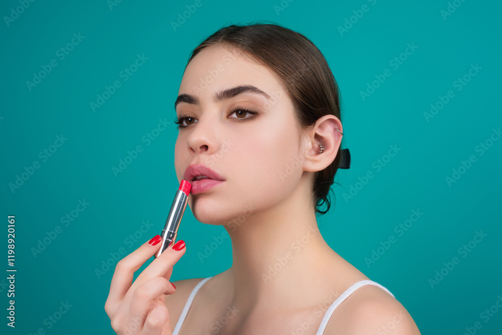 Studio portrait of beautiful woman with red lipstick. Beautiful young woman applying lipstick on her lips, isolated on studio background. Studio portrait of beautiful woman with red lipstick. Beautiful young woman applying lipstick on her lips, isolated on studio background.